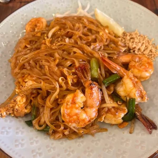 A plate of 8thai shrimp Pad Thai with noodles, bean sprouts, peanuts, and a lime wedge.